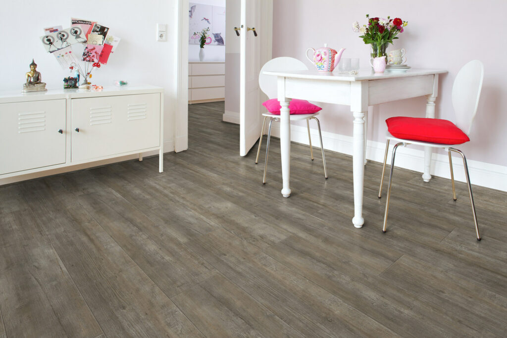 Dunkelbrauner werkhaus Boden in Holzoptik in einem Wohnraum verlegt.