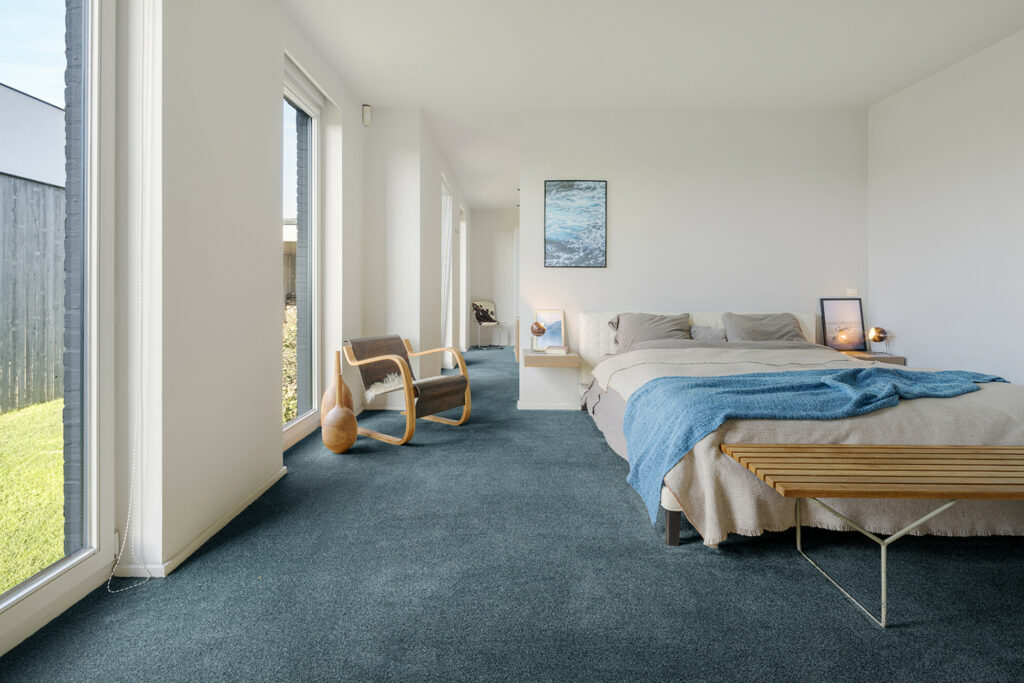 Schlafzimmer mit einem türkisfarbenen werkhaus Teppichboden.